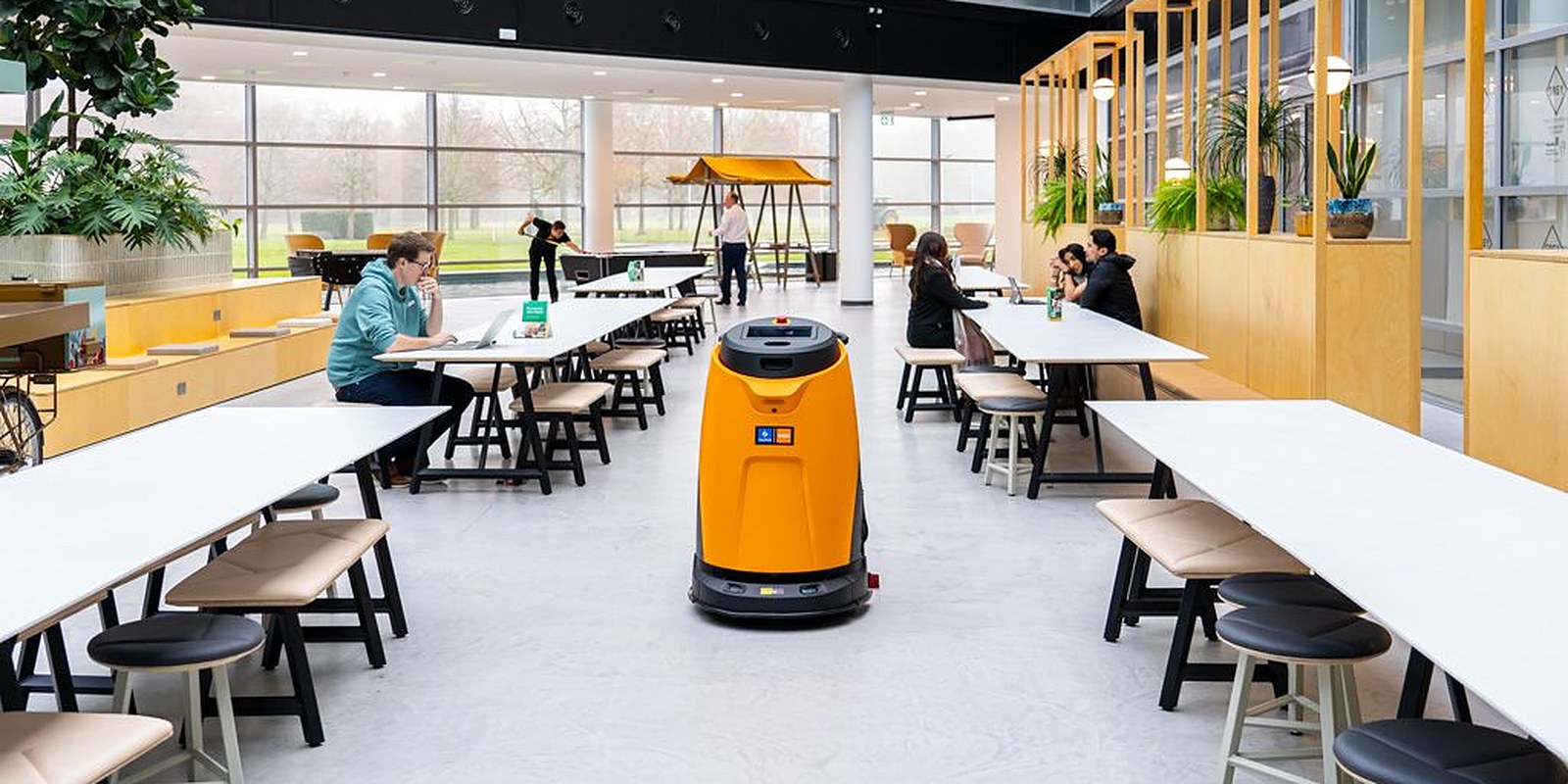 TASKI Ecobot robot pere pod u kantini dok gosti sjede za stolovima